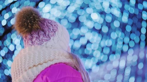 Child Gazing at Blue Christmas Lights at Night
