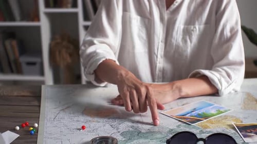 Woman Planning Travel Destination Using Map and Compass