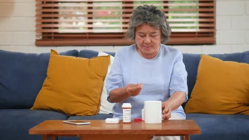 Senior Woman Taking Medication in Her Home