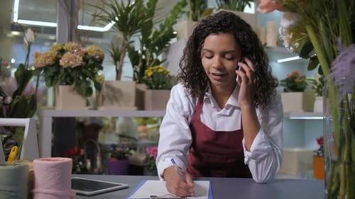 Florist Talking on Phone with Client in Flower Shop