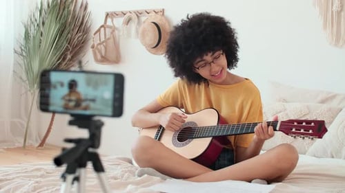 Woman Playing Guitar During Online Music Lesson