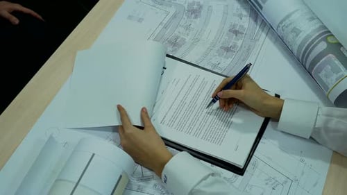 Contract Signing at Desk with Plans