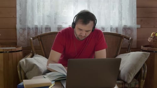 Young Adult Studying At Desk with Laptop and Headphones