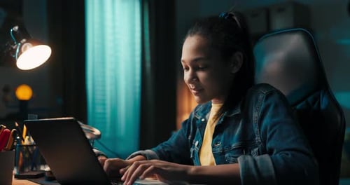 Teen Typing on Laptop while Studying at Desk