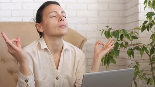Woman Meditating in Front of Laptop at Home