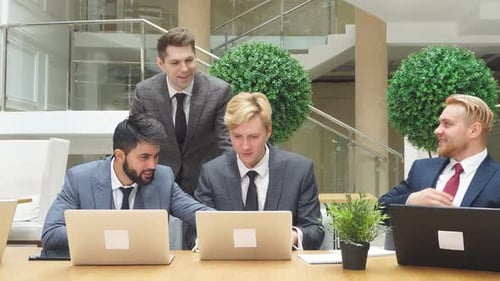 Business People Use Laptop While Having Conversation