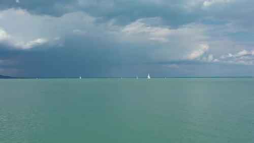 Sailboats on Calm Water Under Cloudy Sky