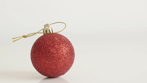 Close-up of shiny red bauble with sequins 4K 2160p 30fps UltraHD tilting footage - Christmas orname