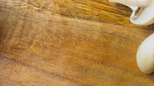 Slicing White Mushrooms on a Wooden Cutting Board