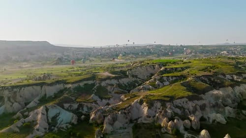 4K Aerial view of Goreme. Colorful hot air balloons fly over the valleys.