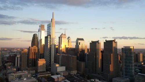 Aerial drone fly away view of the downtown Philadelphia skyline featuring tall, glass skyscrapers at