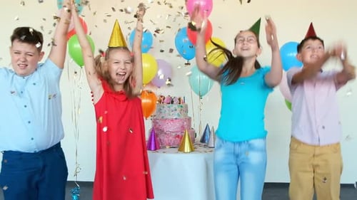 Boys and Girls with Party Cones Throw Confetti at Birthday