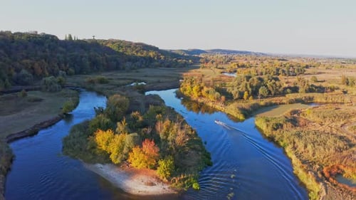 Boat Sails on Curvy River Running Among Forests and Meadows