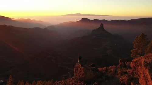 Man On Rock Arch Watching Sunset