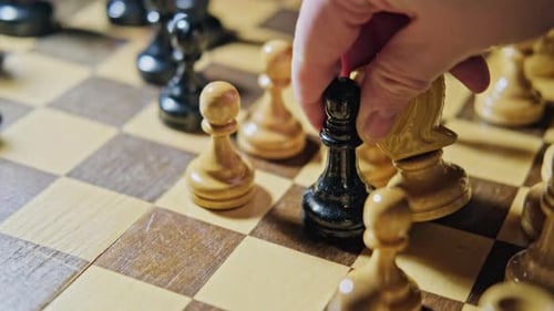 Hand Moves Chess Piece During Strategy Game