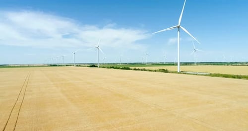Group of windmills for electric power production in the agricultural fields. Aerial view