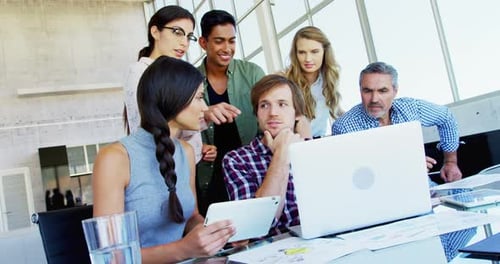 Team Collaborates on Laptop in Modern Office