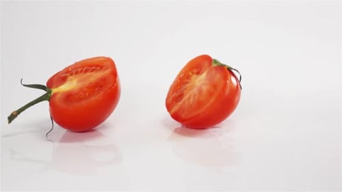 Two Halves of Tomato Breaks Hitting White Surface