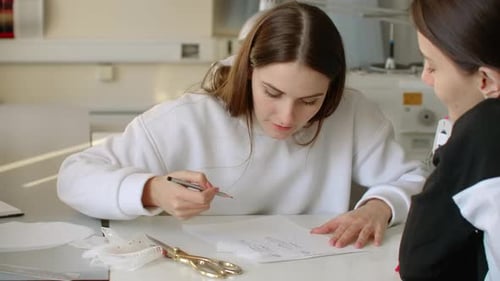 Fashion Designers Drawing and Discussing a Sketch