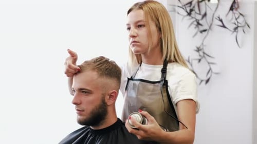 Woman Styling Young Man's Hair in Salon