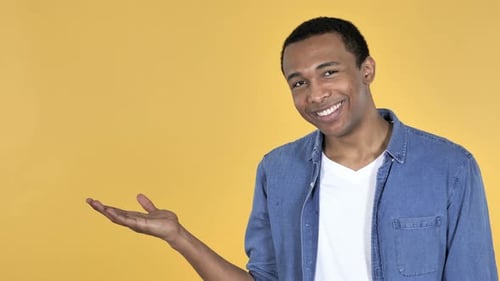 Young African Man Showing Product at Side