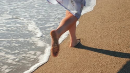 Woman running barefoot at sea beach