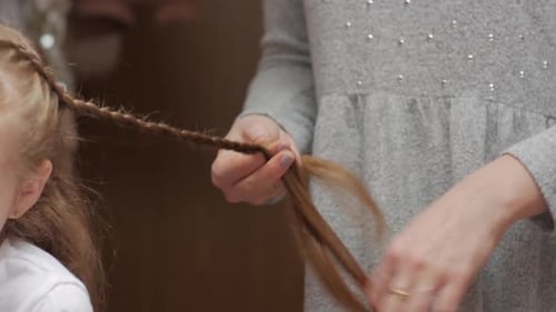Woman Braids A Girl