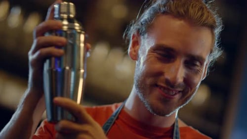 Smiling Bartender Mixing Cocktails in Shaker