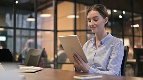 Woman Using Tablet at Desk in Modern Office