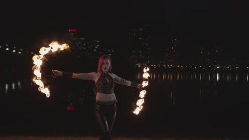 Female Fire Dancer Performing at Night on Riverside