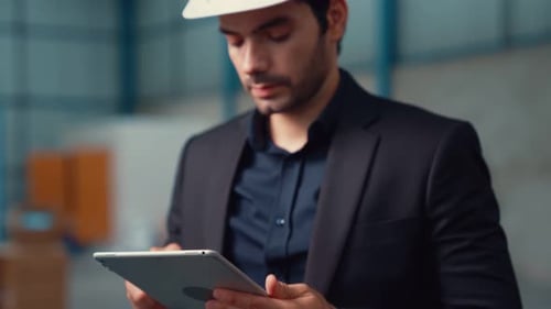 Factory Manager Using Tablet Computer in Warehouse or Factory