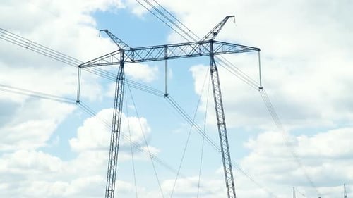 Moving Through Electric High Voltage Pylon Against Beautiful Sky