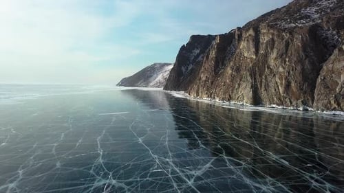 Ice with Cracks in Lake Baikal in Winter. Sagan-Zaba Cliff, Aerial View.