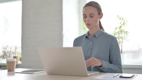 Woman Having Back Pain While Using Laptop in Office