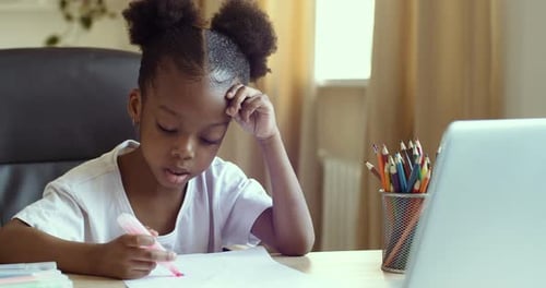 Child Drawing with Marker at Desk Indoors