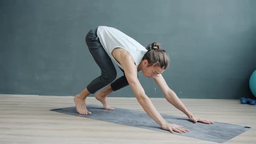 Slow Motion of Skilled Yoga Trainer Demonstrating Balancing Pose Indoors in Modern Studio