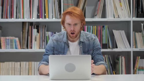 Man Reacting to Content on Laptop