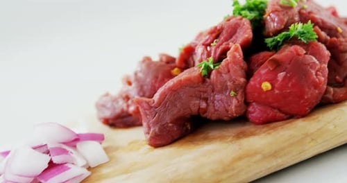 Marinate beef pieces on wooden board