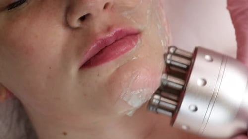 Woman Receiving Facial Treatment with Metallic Tool