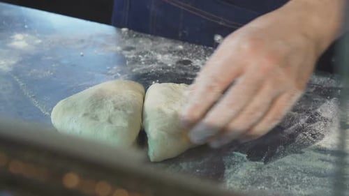 Professioneller Bäcker schneidet Teig in der Küche