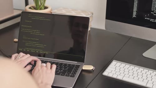 Female Software Developer Typing Program Code on Laptop