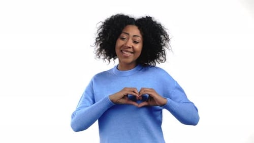Smiling Woman Makes Heart Shape with Hands
