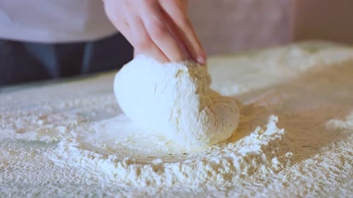 Nahaufnahme der Herstellung von Teig mit weiblichen Händen in der Bäckerei