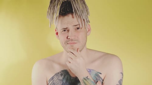 Thoughtful Man with Dreadlocks Posing in Studio