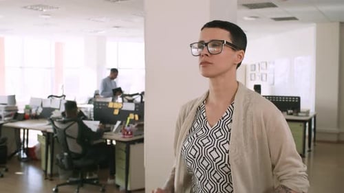 Woman Carrying Clipboard and Walking through Office