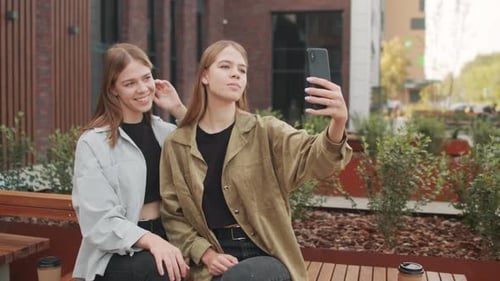 Twin Sisters Taking Selfie Outside