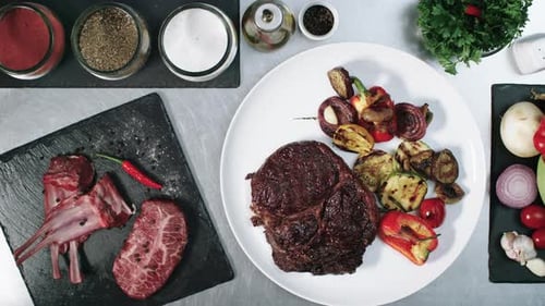 Chef Plating Steak and Grilled Vegetables on Plate