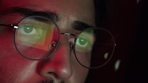 Focused Person Looks at Screen in Dark