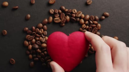 Red Heart Resting on Coffee Beans