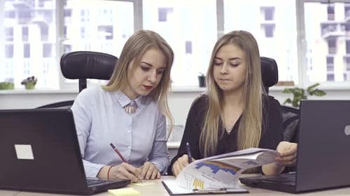 Zwei Büroangestellte schauen sich Geschäftscharts an